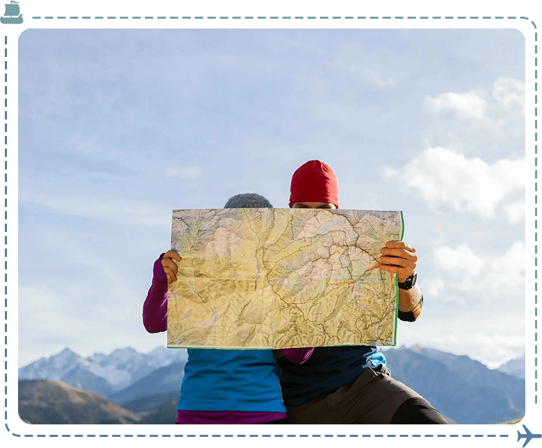 Two people holding a map in front of their face.