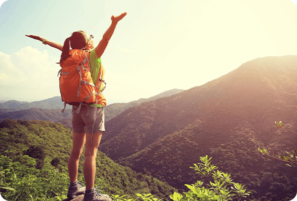 A person with a backpack on standing in the mountains